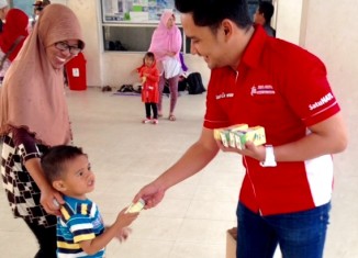 Sauqi Maulana, Corporate Communication PT Trio Motor membagikan susu gratis kepada anak-anak di Menara Pandang Siring Tendean Banjarmasin