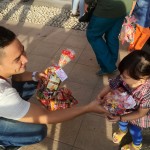 Corporate Communication PT Trio Motor, Sauqi Maulana saat membagikan bingkisan snack untuk seorang anak.