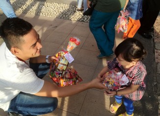 Corporate Communication PT Trio Motor, Sauqi Maulana saat membagikan bingkisan snack untuk seorang anak.