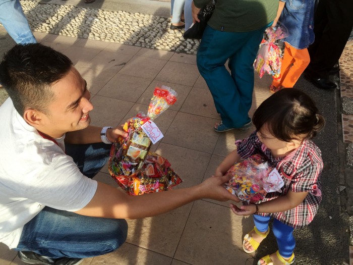 Corporate Communication PT Trio Motor, Sauqi Maulana saat membagikan bingkisan snack untuk seorang anak.